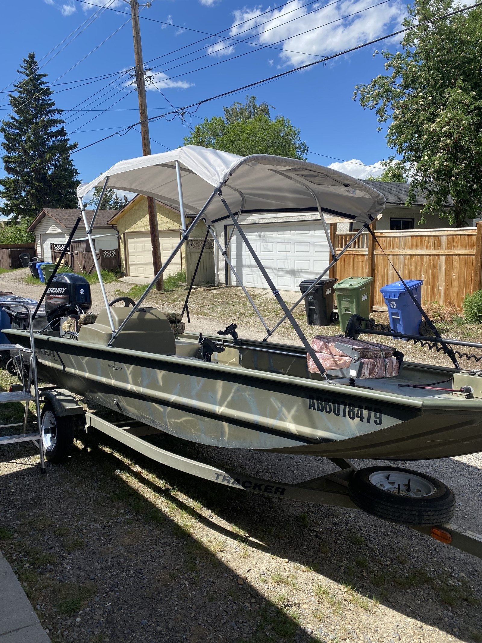 Side view of the new Tracker boat setup with canopy and Mercury 4-Stroke 60/40 jet outboard
